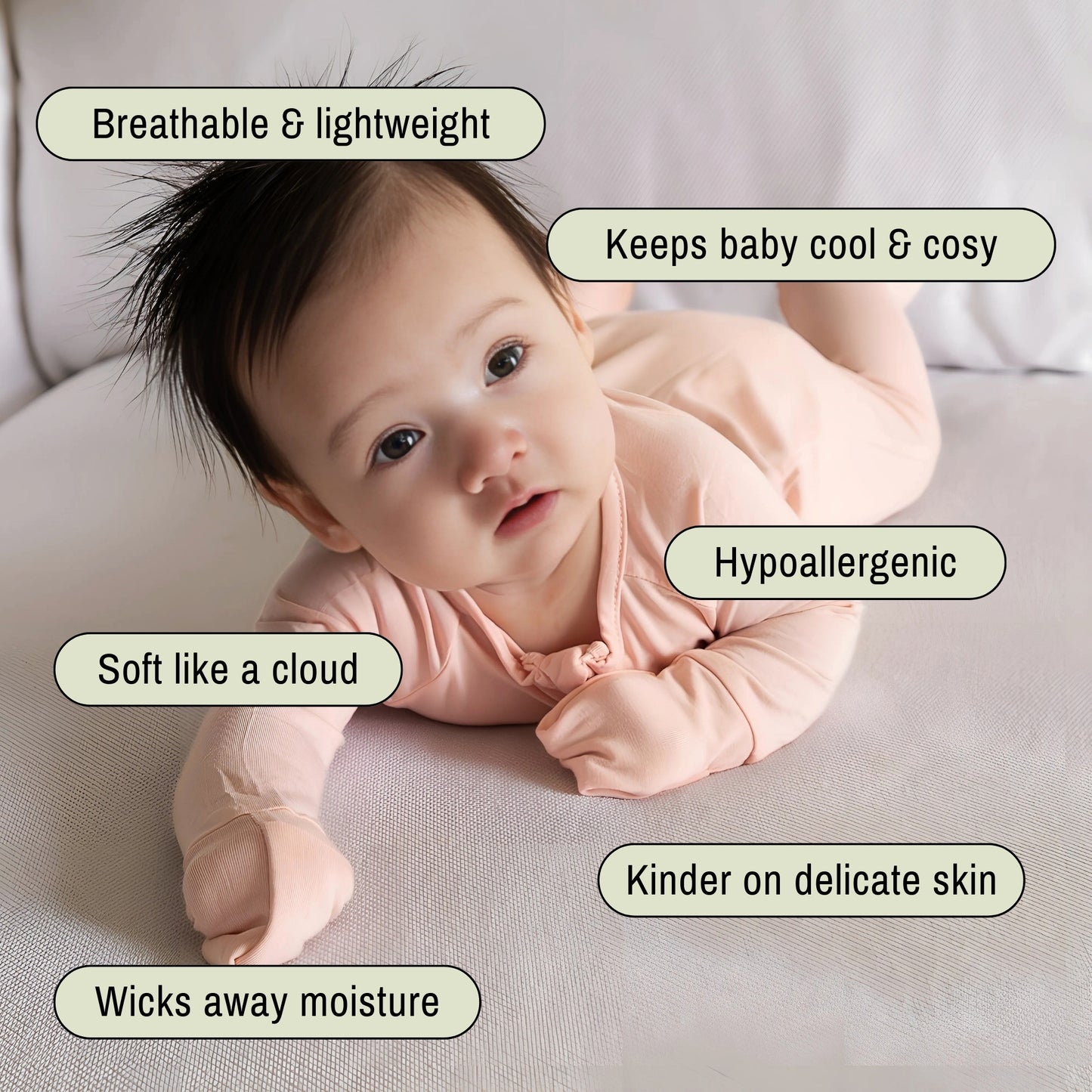 Baby in a peach onesie lying on sofa
