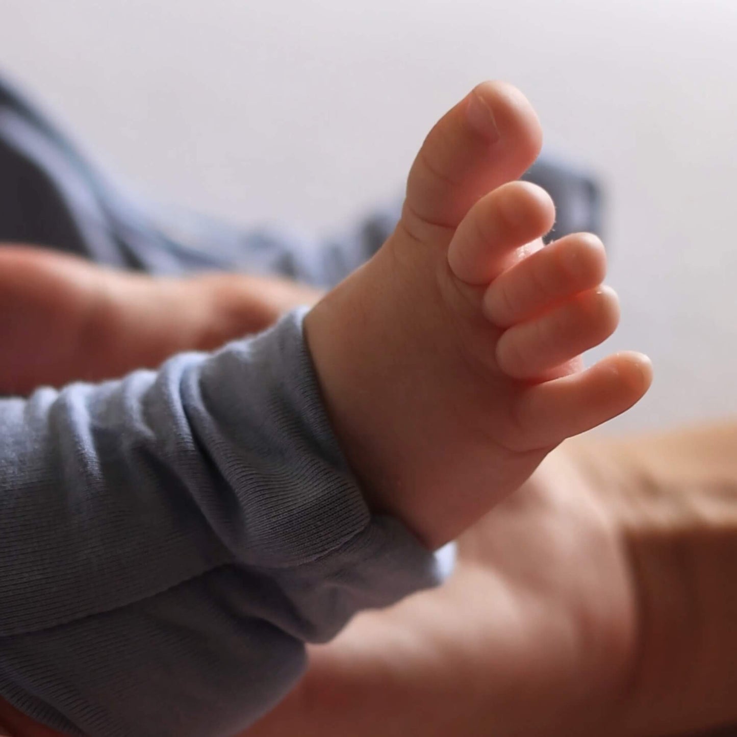 Baby wearing dark blue pyjama foot close up