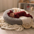Baby sleeping wearing a maroon bamboo baby grow and bow