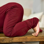 Baby wearing a maroon bamboo baby grow close up off fabric