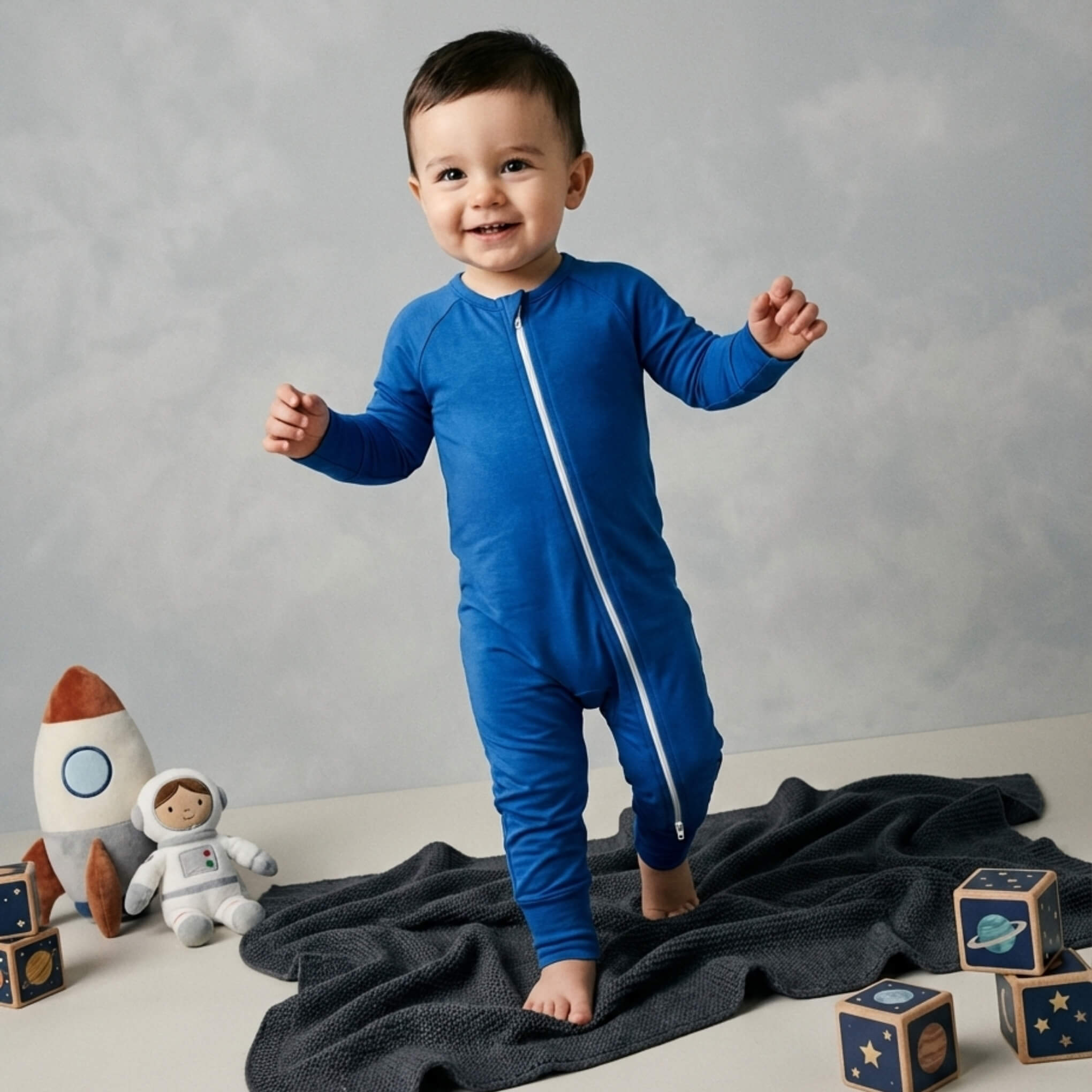 Toddler wearing deep blue bamboo baby grow walking