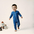 Toddler wearing deep blue bamboo baby grow