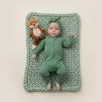 Baby in green baby grow with bow