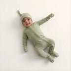 Baby wearing a green onesie and hat
