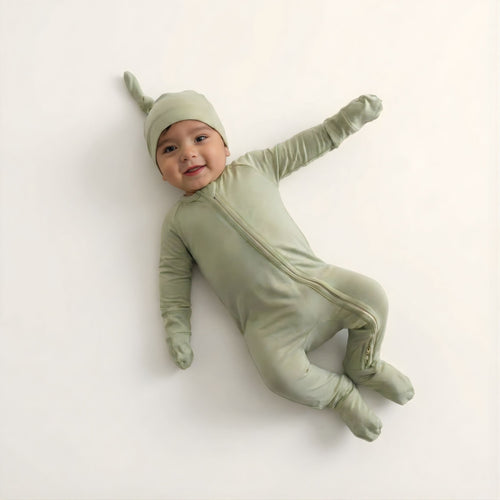 Baby wearing a green onesie and hat