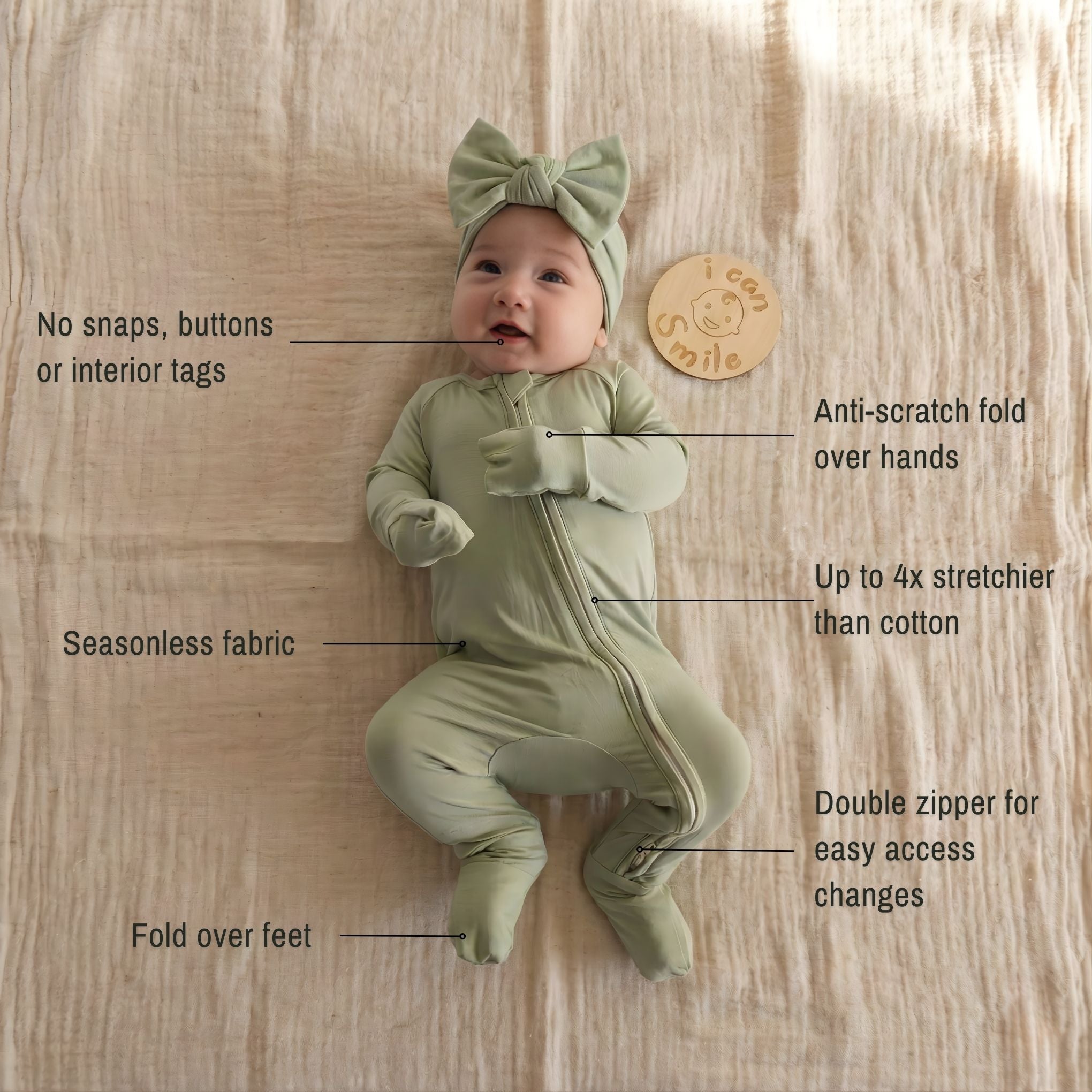 Baby girl wearing a green pyjamas laying on white blanket