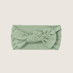Green headband with a bow on a beige background