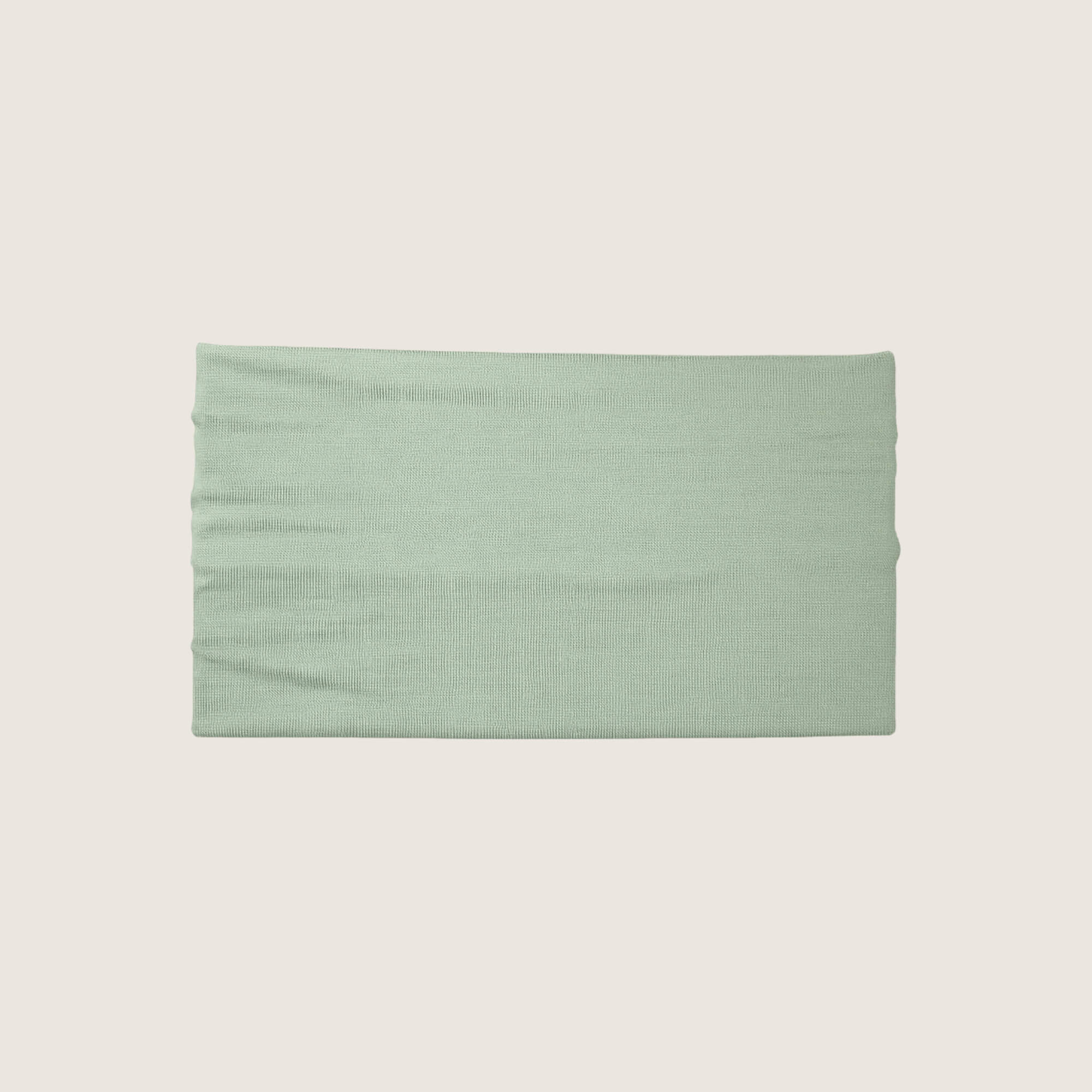Green headband on a beige background