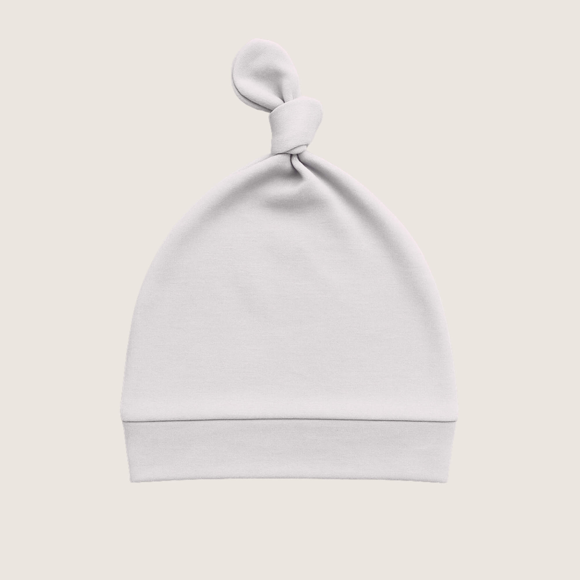 Grey baby hat with a knot on top against a light beige background