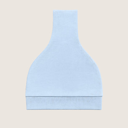 Light blue knotted hat folded on a beige background