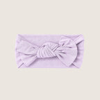 Lavender headband with a bow on a light beige background