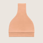 Orange baby hat folded with a knot on a light grey background