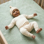 newborn wearing a light brown bamboo baby hat