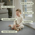 Toddler sitting wearing a light brown bamboo baby grow