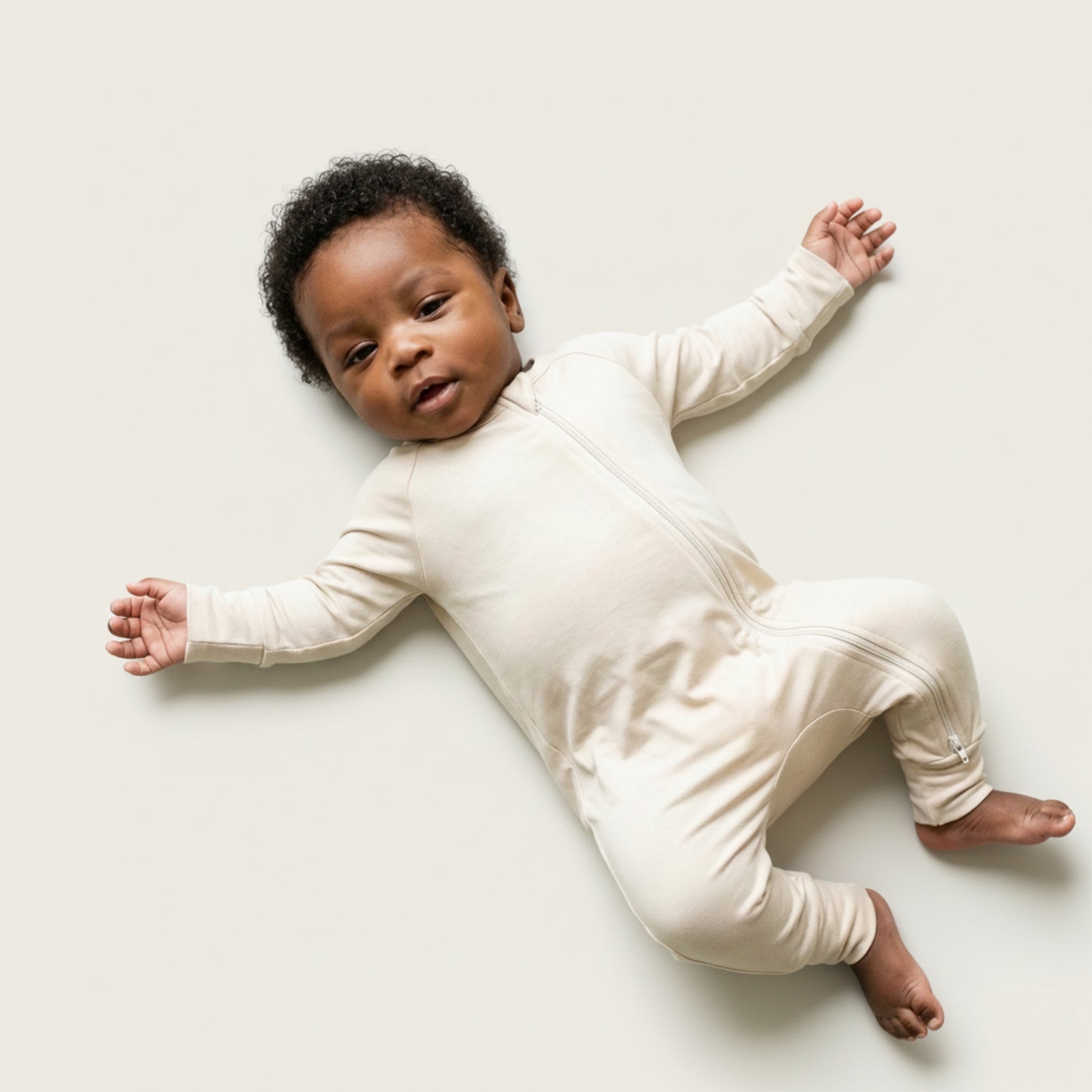 Baby wearing a light brown bamboo baby grow