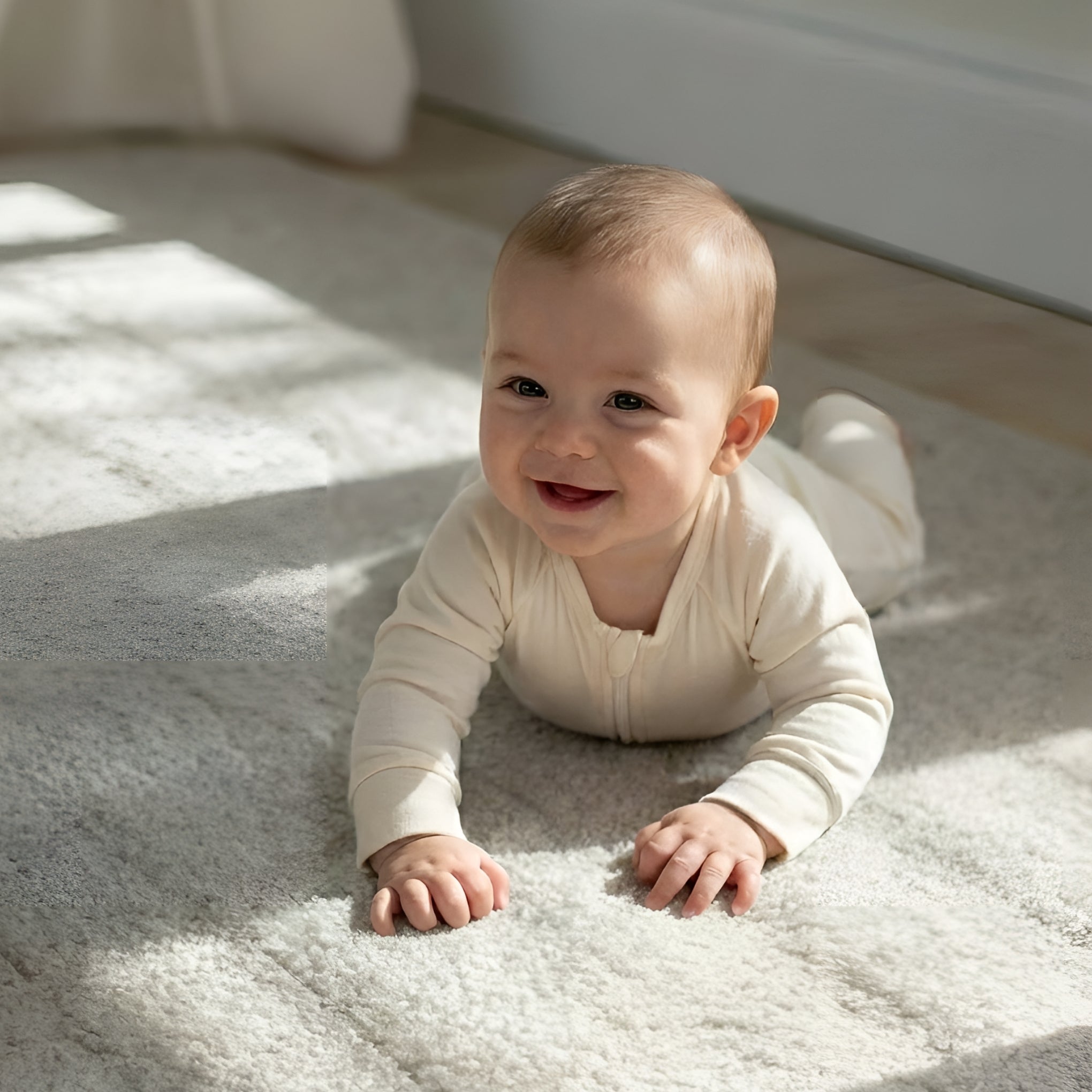 Baby wearing a light brown bamboo baby grow laying in room