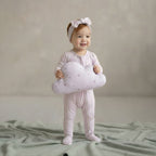 toddler girl wearing a lavender pyjamas standing in studio