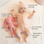 Baby in a peach onesie  laying on white background