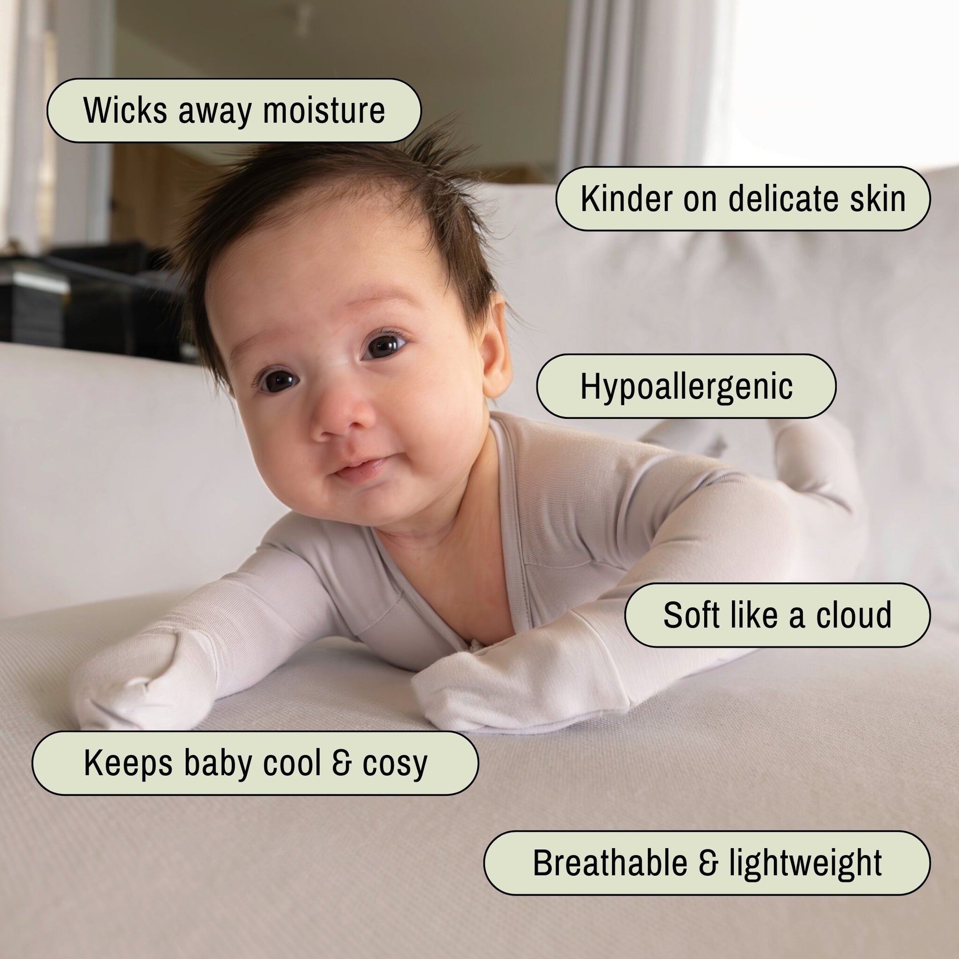 Baby wearing a light grey pyjamas laying on tummy