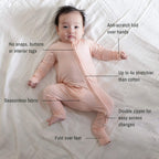 Baby wearing a pink bamboo pyjamas laying on white blanket