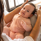 Baby wearing a pink bamboo pyjamas in mums arms