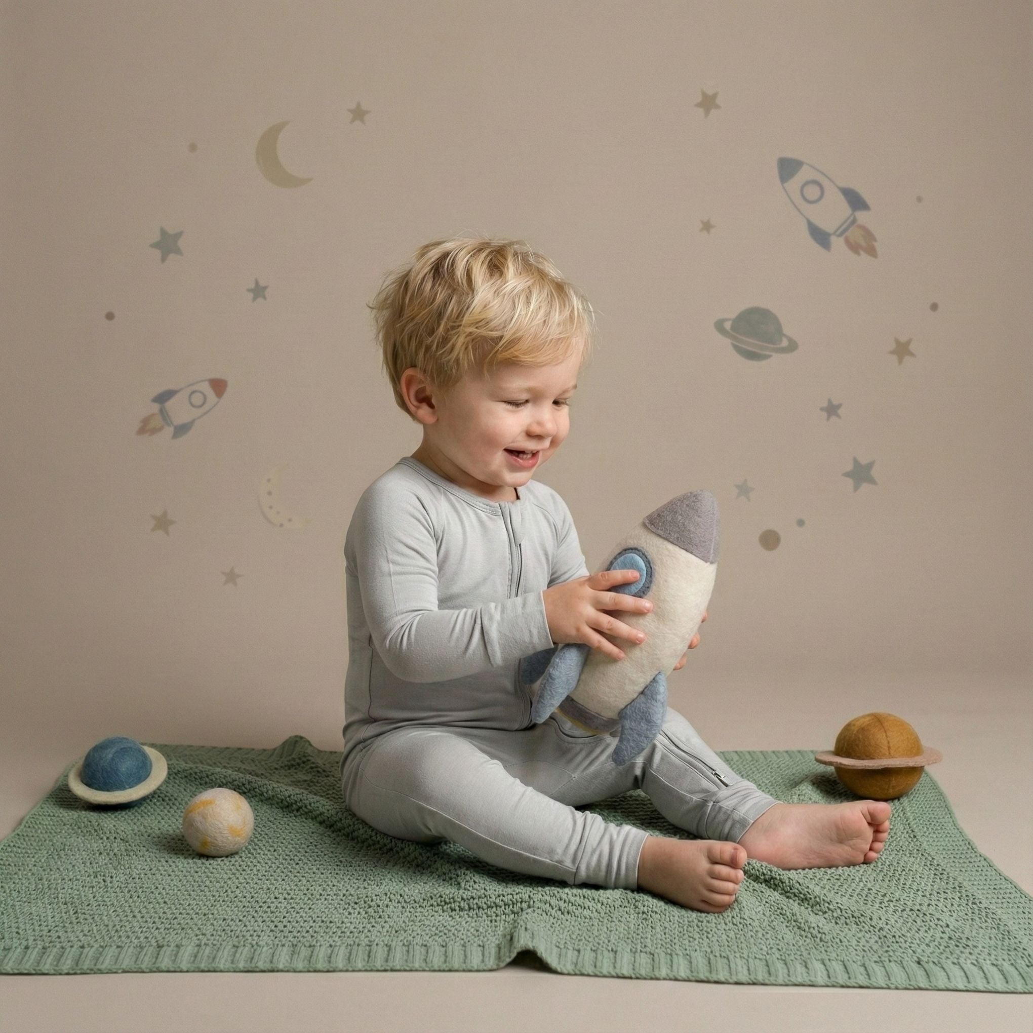 Boy toddler wearing a light grey pyjamas sitting down