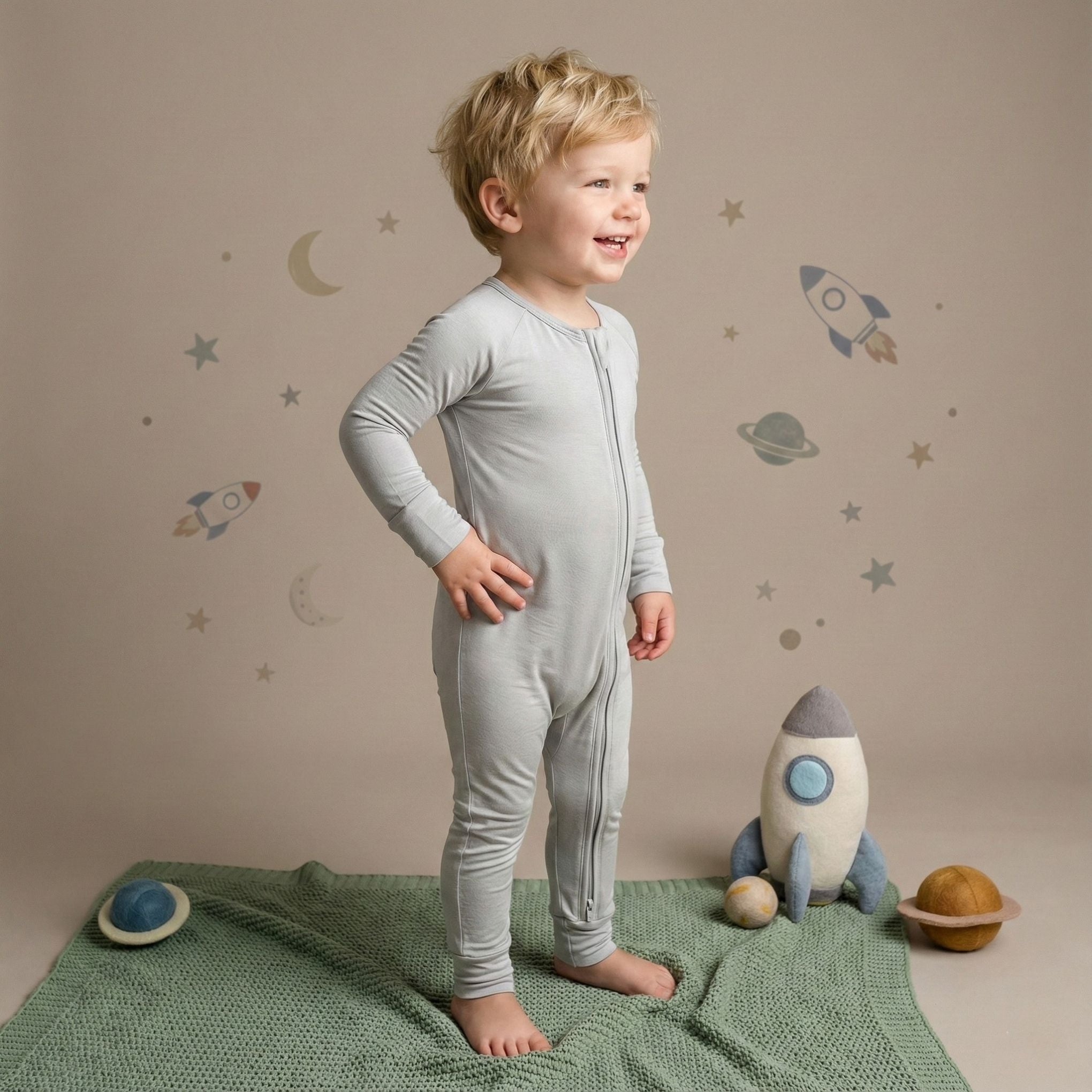Boy toddler wearing a light grey pyjamas standing up
