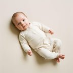 Newborn wearing white babygrow