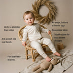 Toddler sitting in off white babygrow