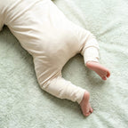 back of baby wearing off white babygrow