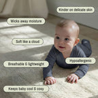 Baby in a grey bamboo baby grow on a carpet