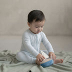 toddler baby boy wearing blue baby grow sitting