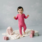 toddler girl wearing pink bamboo babygrow standing