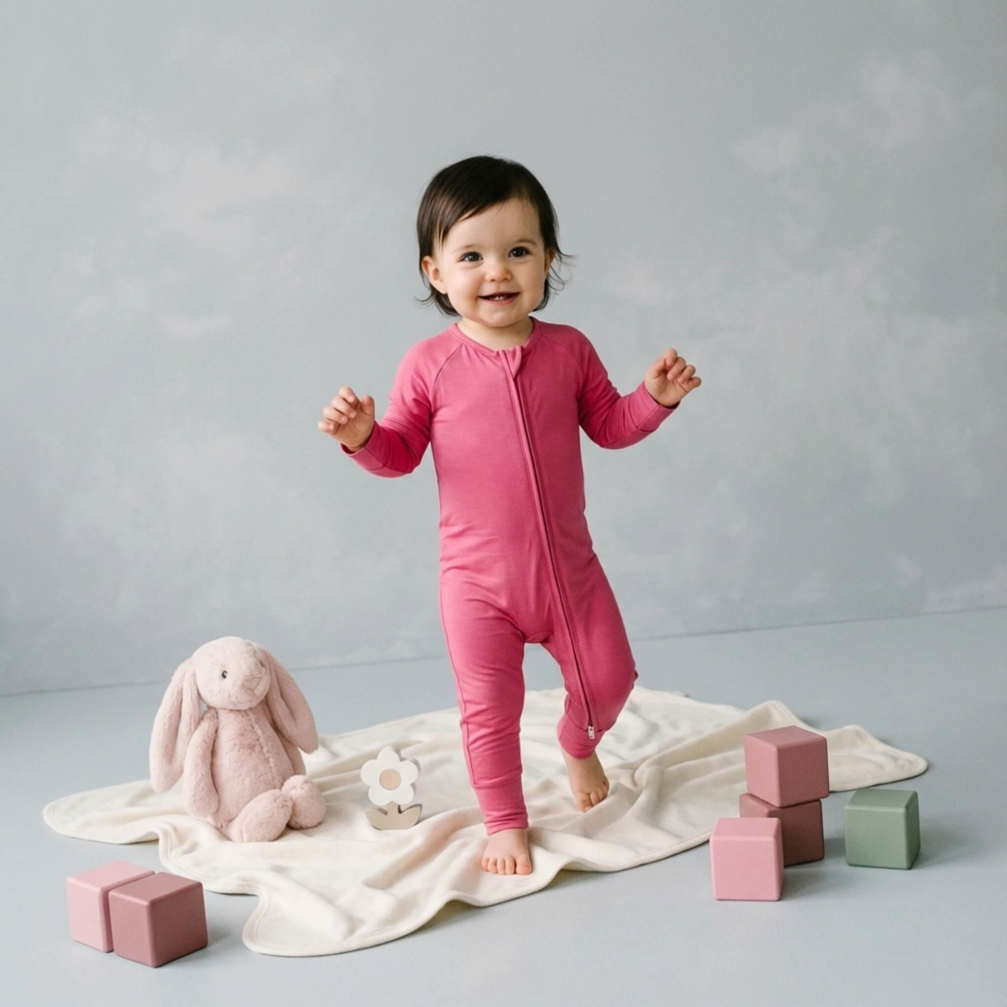 toddler girl wearing pink bamboo babygrow standing