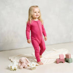 toddler girl wearing pink bamboo babygrow standing