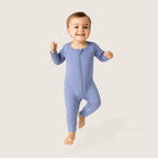 Child wearing a blue onesie on a light gray background