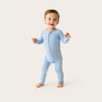 Baby wearing a light blue onesie on a white background