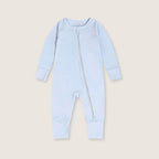 Light blue baby onesie with a zipper on a beige background