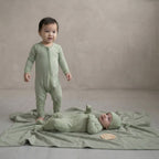toddler and baby girl wearing green baby grows in studio