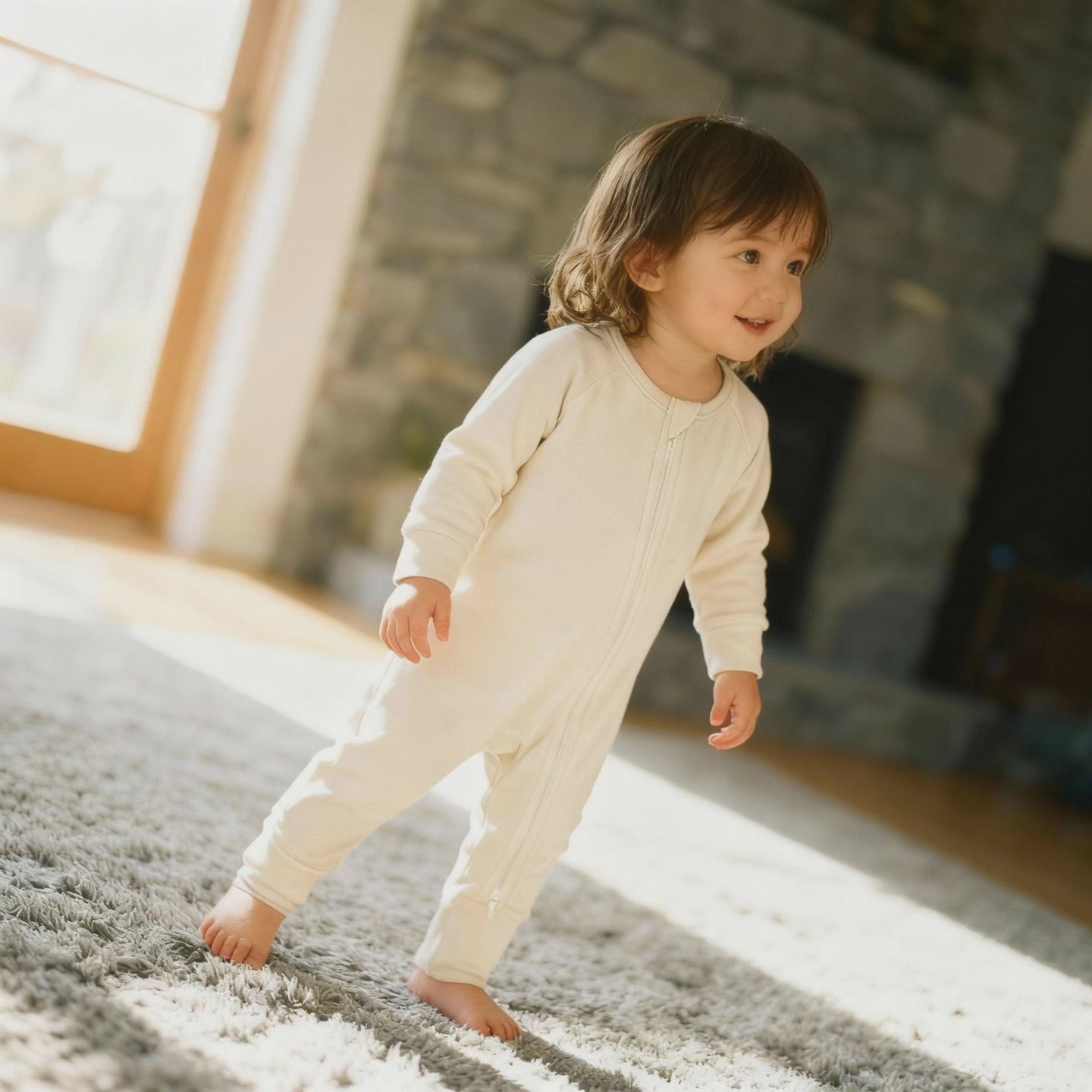 Video of toddler Baby wearing a light brown bamboo baby grow