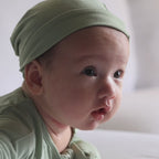 Baby wearing Green pyjama tummy time