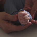 Baby wearing dark blue pyjama hand close up