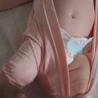 Baby wearing pink pyjama being changed