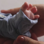 Baby wearing dark blue pyjama foot close up
